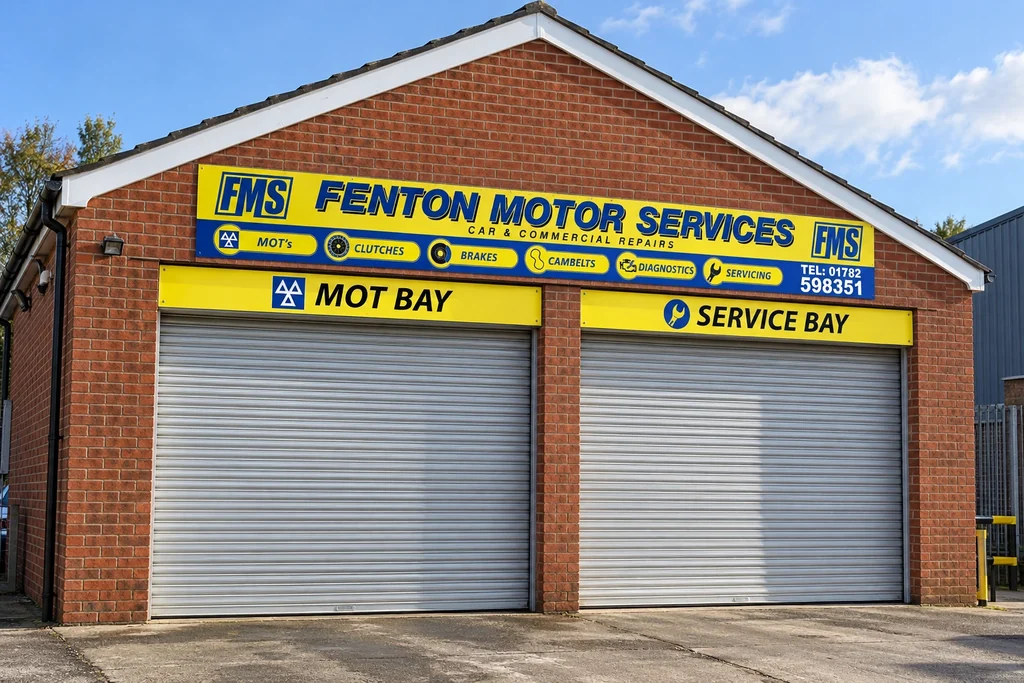 Realistic Fenton Motor Services garage-front mock-up with thin yellow and blue flat fascia panels above MOT and service bays