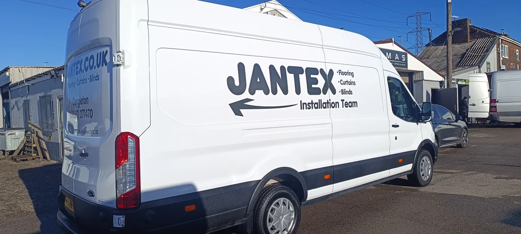 Jantex installation-team van with dark lettering on its white side panel