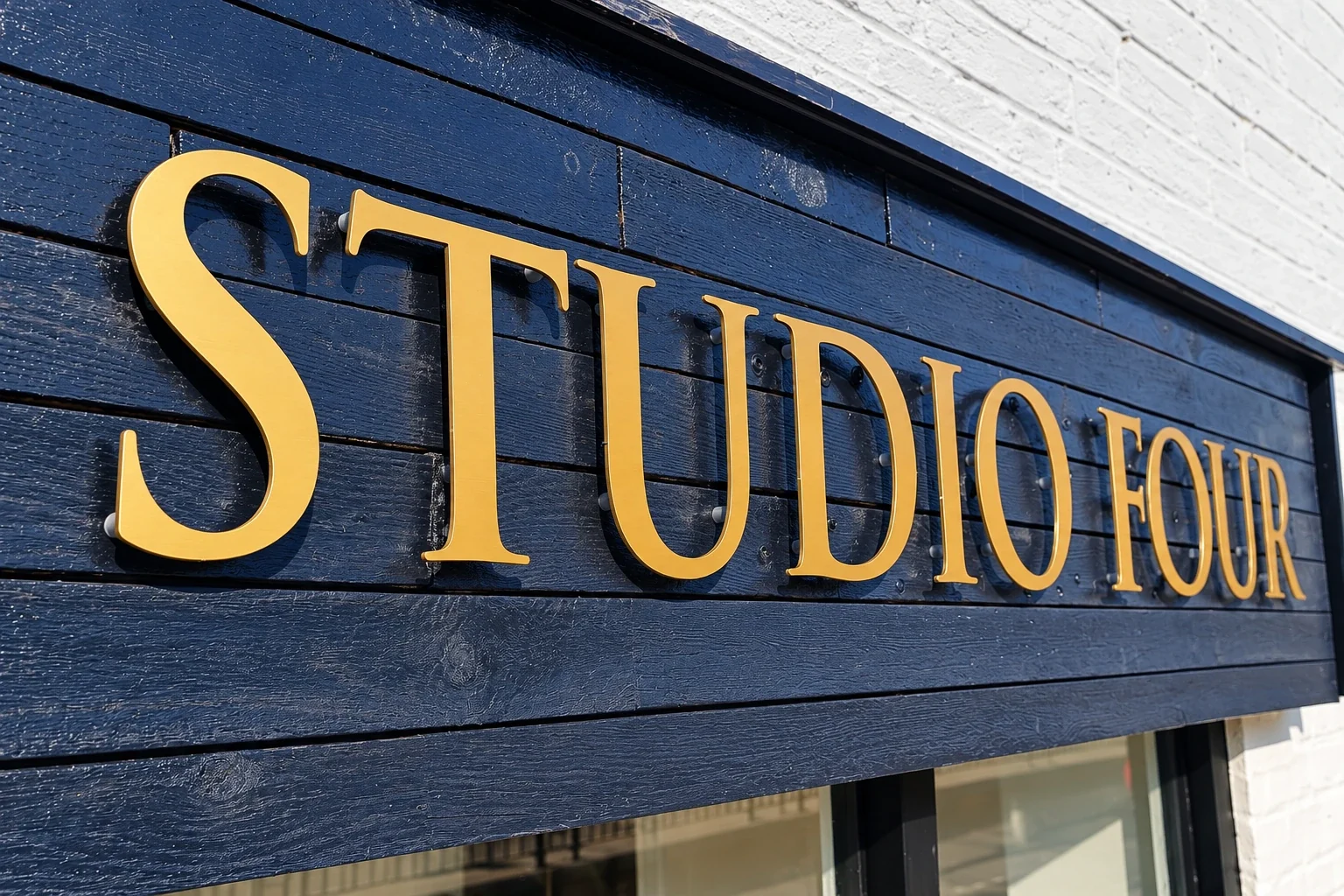 Completed Studio Four raised gold lettering on a navy fascia