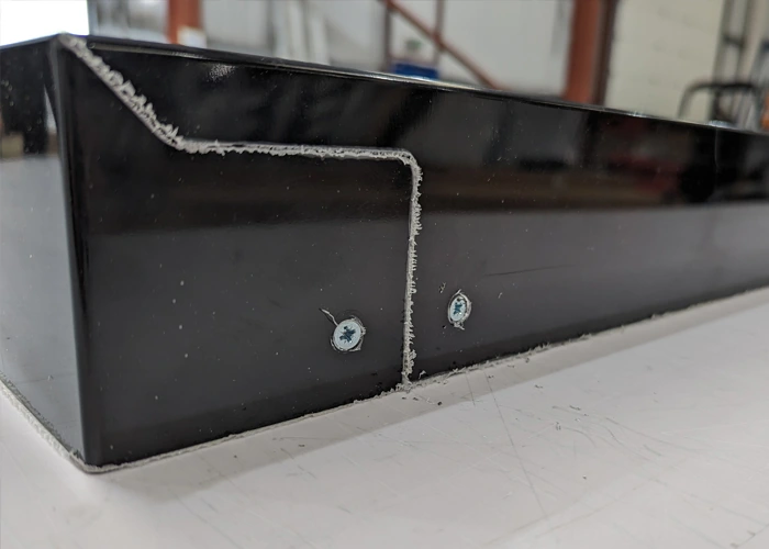 Rear construction detail showing how the folded returns meet at a sign tray corner
